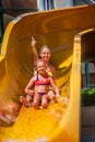 Children at water park slide down and show thumbs up. Royalty Free Stock Photo