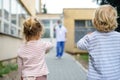 Children waving at father doctor in front of hospital, coronovirus and isolation concept.