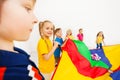 Children waving parachute full of colorful balls