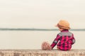 Children wear hat and red jacket sitting lonely on the ground. Royalty Free Stock Photo