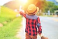 A children wear hat and walking on road.