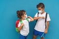 Children wearing face protective mask going back to school during corona virus pandemic - Little kids doing new social distance