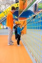 Children wearing harnesses learning how to clip and unclip carabiners