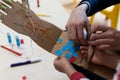 Children is wearing a robotic arm made with cardboard