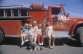 Children wearing sunglasses with a fire truck,