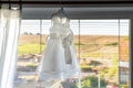 children wedding dress hanging on window cornices