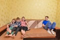 The children were offended by the older brother, the boy is sitting separately from the guys on the couch Royalty Free Stock Photo