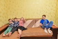 The children were offended by the older brother, the boy is sitting separately from the guys on the couch Royalty Free Stock Photo