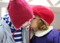 Children, winter red hat whispering in ear Royalty Free Stock Photo