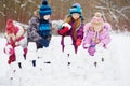 Children work at building wall from snow blocks