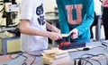 Children work in the training center on wood processing machines. Education in Fablab.