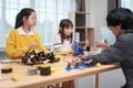 children working on circuit boards of small robot at technology and engineering workshop