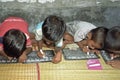 Children writing with chalk on slates, Bangladesh