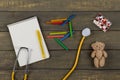 Children& x27;s doctor or pediatrician concept - blank notepad, pills, yellow stethoscope, Teddy bear toy, crayons Royalty Free Stock Photo