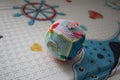 Children's educational toy rolls on the carpet in the nursery. Handmade bizikubik on a multi-colored children's