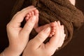 Children& x27;s foot in the hands of mother, father, parents. Feet of a tiny newborn Royalty Free Stock Photo
