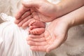 Children& x27;s foot in the hands of mother, father, parents. Feet of a tiny newborn close up. Little baby legs. Royalty Free Stock Photo