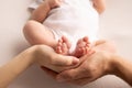 Children& x27;s foot in the hands of mother, father, parents. Feet of a tiny newborn close up. Little baby legs. Royalty Free Stock Photo