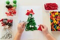 Children& x27;s hands creating Christmas tree from dyed pasta for the holiday of Christmas. Sensory play for childs