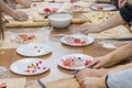 Children& x27;s hands are cutting food for making their first pizza on wooden table. Cooking master class