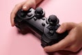 Children& x27;s hands hold a joystick, gamepad, playing video games on a pink background Royalty Free Stock Photo