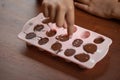 Children& x27;s hands squeeze using pastry bag filling hot melt chocolate into silicone mold.  Selective focus Royalty Free Stock Photo