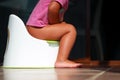 Children's legs hanging down from a chamber-pot