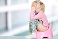 Children's legs hanging down from a chamber-pot on a blue background Royalty Free Stock Photo