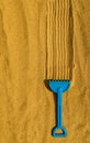 childrens plastic rake lying on the yellow sand