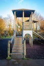 Children's playground wooden play structure fort with wood step ladder bridge and high tower. Royalty Free Stock Photo