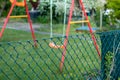 swing in a garden behin a fence, Focus on the fence Royalty Free Stock Photo