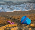 Children's toys on a sandy beach, blue sky and the sea in the background Royalty Free Stock Photo