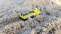 Children yellow car toy model in sand