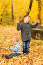 Children in yellow and gold autumn forest. Two little brothers on leafs in fall park. Family walk outdoor. Friendly relationship Royalty Free Stock Photo