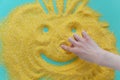 Childrens hand draws on corn grits on a blue background. The concept of quarantined games.