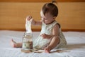 Childrens hands with money in glass jar