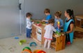 Childrens playing with their teacher at Kindergarten in classroom