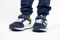 Childrens shoes. Blue kids running shoes sneakers on the legs of a five- or six-year-old boy on a white background. Royalty Free Stock Photo