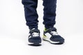Childrens shoes. Blue kids running shoes sneakers on the legs of a five- or six-year-old boy on a white background. Royalty Free Stock Photo