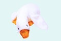 Childrens toy stuffed animals. Soft white plush toy duck for kids isolated on a light blue background. Duck teddy toy. White duck