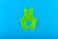 childrens toy for teeth. in the form of a hare. Green colour. Brush your teeth. on a blue background. Place for an inscription.