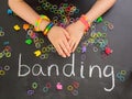 Childs arm with loom band bracelets on a blackboar Royalty Free Stock Photo