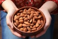 Childs delight close up of a hand holding a bowl, almonds within