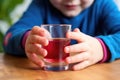 childs hand grabbing a glass of beetroot juice