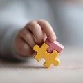 Childs hand holding two colorful puzzle pieces connected, symbolizing unity, problemsolving, and early education. Perfect for Royalty Free Stock Photo