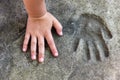 Childs hand and memorable handprint in concrete