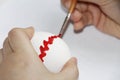 Childs hand paints an Easter egg with a brush Royalty Free Stock Photo