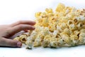 A Childs hand reaching for some popcorn