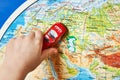 Childs hand with toy car on map of Eurasia