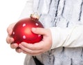 Childs hands holding red christmas ball